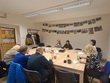 Deskové hry pro dospělé dokazují, že zábava tohoto typu se netýká pouze dětí. Tuto hru si můžete zahrát sami, s partnerem, i s přáteli. Na fotografii zachyceni zleva: p. Limberková, p. Ing. Píza, p. Oherová, sl. Lacková (praktikantka-čte a zodpovídá otázky), p. Mašková (dobrovolnice), p. Rytychová, p. Ing. Beránek, p. Limberk