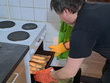 Na fotografii zachycen p. Šopa, který vkládá vykynuté rohlíky do předehřáté trouby