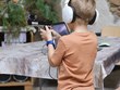 Zvuková střelba na akci Neviditelná ZOO - kolemjdoucí chlapec se sluchátky míří na terč speciální zvukovou pistolí